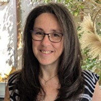 Portrait souriant d’une femme brune portant des lunettes